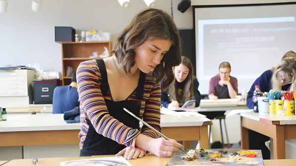Una estudiante de la Mannahouse Christian Academy se concentra en un proyecto de manualidades en el aula.