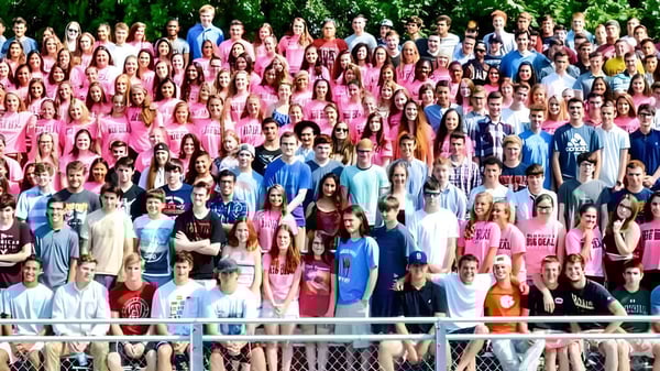Un grupo de jóvenes está de pie juntos en el área verde del terreno de la Marblehead High School.