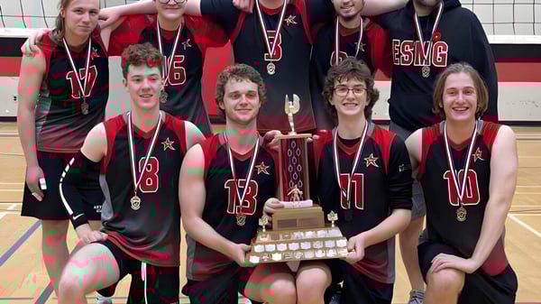 Un grupo de estudiantes de la École secondaire publique Marc-Garneau posan con un trofeo en la cancha de baloncesto.