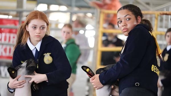 Dos estudiantes de Marion County Public Schools en uniformes de policía están en una estación de policía o instalación de entrenamiento.