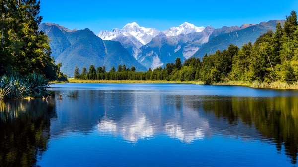Un lago tranquilo con el reflejo de las montañas nevadas y densos bosques cerca del Marist College.