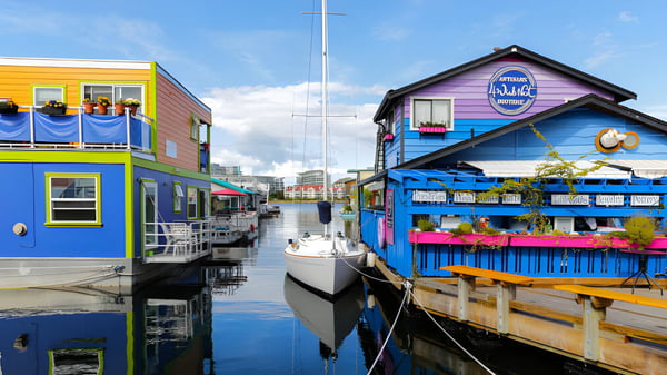 Casas de madera coloridas junto al agua con botes frente a la Mark R. Isfeld Secondary School.