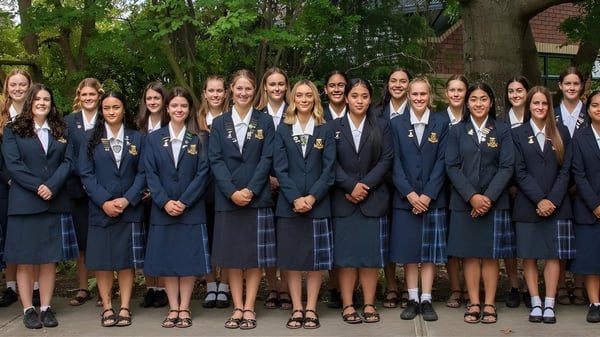 Un grupo de jóvenes estudiantes de Marlborough Girls está reunido en una zona exterior boscosa.