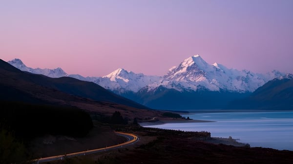 Una carretera sinuosa atraviesa un paisaje tranquilo con montañas cubiertas de nieve al fondo del campus de Marlborough Girls.