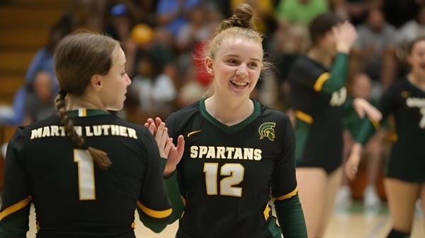 Dos estudiantes de la Martin Luther High School están juntas en la cancha de baloncesto con camisetas de los Spartans.