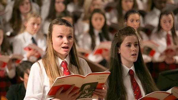 Alumnos de The Mary Erskine School cantan juntos en el coro en un escenario.