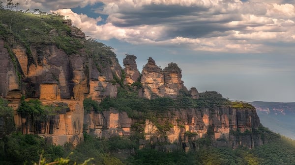 Formaciones rocosas se elevan ante un cielo nublado en el entorno natural de la Maryborough State High School.
