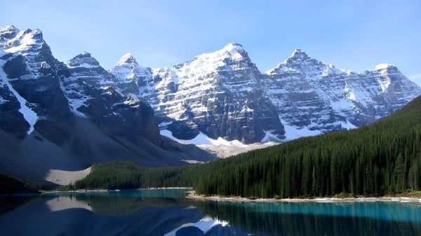 Un lago turquesa con montañas nevadas y un paisaje forestal cerca de la Massey-Vanier High School.