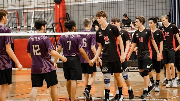 Un grupo de jóvenes jugadores de voleibol se reúne en el campo de voleibol de la Master's Academy and College.