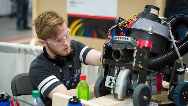 Un estudiante de la Matthew Halton High School trabaja concentrado en equipo técnico en un taller.