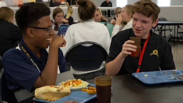 Estudiantes de la Maur Hill-Mount Academy conversan y comen juntos en el comedor.