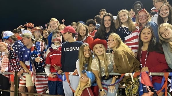 Un grupo de estudiantes de la Maynard High School posan juntos sonriendo para una foto grupal con ropa patriótica.