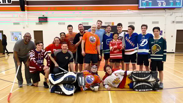 Un grupo de alumnas y alumnos de la McNally High School posan como equipo de hockey en el gimnasio.