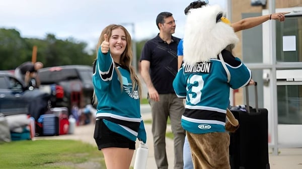 Un grupo de personas está afuera conversando en el campus de la Memorial University.