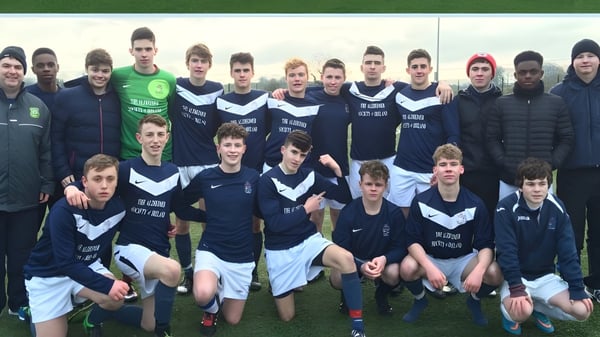 Un grupo de jóvenes futbolistas está en el campo de deportes de la Mercy Secondary School.