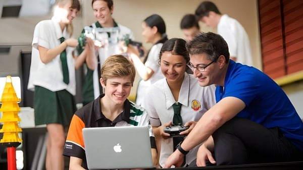 Un grupo de estudiantes de la Merrimac State High School trabaja juntos en un laptop.