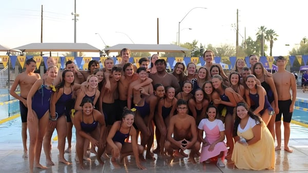 Un grupo de estudiantes de la Mesa High School se reúne en el área de la piscina para una foto grupal.