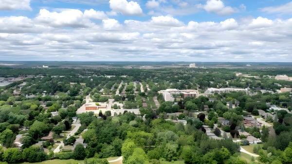 Un paisaje verde con vista a una gran ciudad bajo un cielo nublado en la Metro International Secondary Academy.