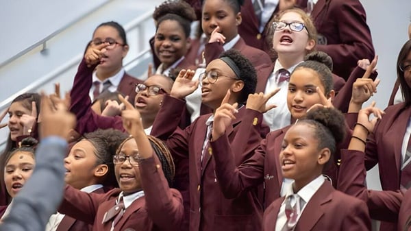 Estudiantes de la Miami-Dade County Public School levantan activamente las manos en clase.