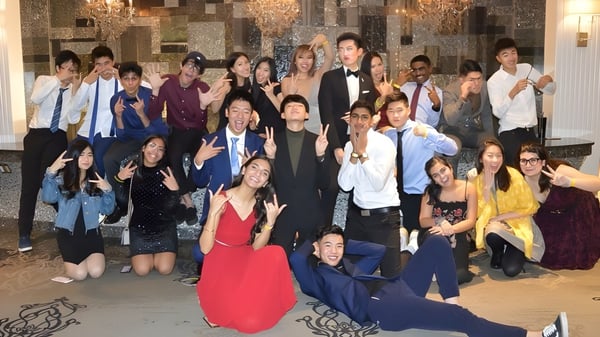 Un grupo de personas vestidas de manera formal se reúne en una sala lujosa en el campus de la Milliken Mills Secondary School.