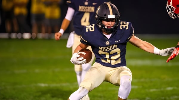 Un jugador de fútbol de la Mission College Preparatory Catholic High School corre con el balón en el campo.