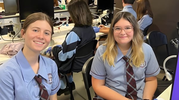Un grupo de estudiantes en uniformes escolares está en un aula de la Mitchelton State High School.