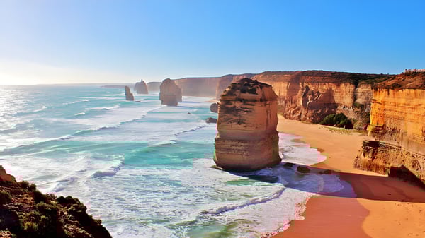 Vista de una costa rocosa con playa de arena y mar turquesa cerca de la Mitchelton State High School.