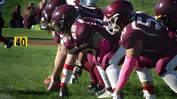 Un grupo de jugadores de fútbol en los colores de la M.M. Robinson High School está en un campo de fútbol con marcas.