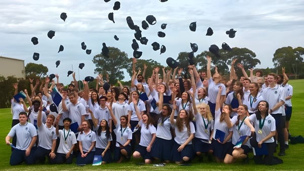 Un grupo de estudiantes de Modbury High School lanza sus gorras al aire para celebrar.