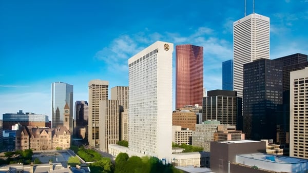 Un vibrante horizonte urbano con altos rascacielos frente a un cielo azul cerca del Monarch Park Collegiate Institute.