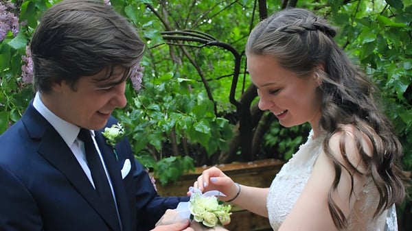 Una pareja en ropa formal está en el área verde exterior del Monarch Park Collegiate Institute y se miran.