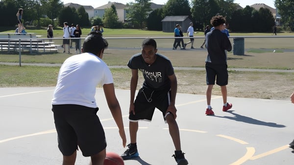 Alumnos de la Monsignor Doyle Catholic Secondary School durante la clase de educación física en la cancha de baloncesto al aire libre.