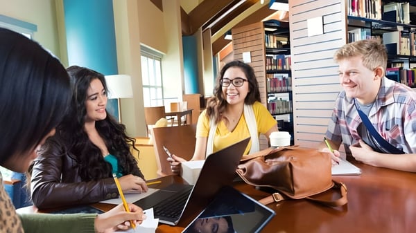 Un grupo de estudiantes de la Montcalm Secondary School trabaja juntos con laptops en un área de estudio.