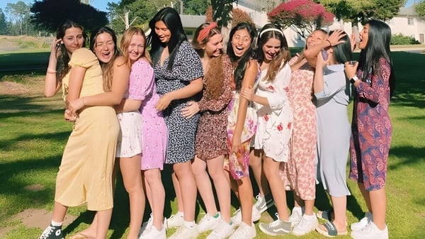 Un grupo de estudiantes de la Monterey Bay Academy está al aire libre en un prado y se abrazan.