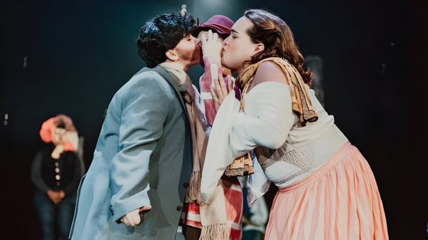 Estudiantes de la Montpelier Roxbury Public School District realizan una escena de teatro en un escenario oscuro con un abrazo y un beso.