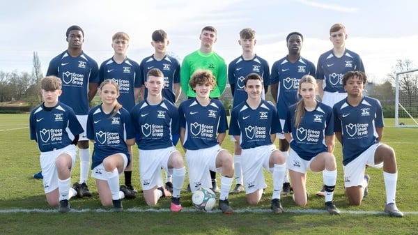 Un grupo de estudiantes de la Moorland School posan juntos en un campo de fútbol.