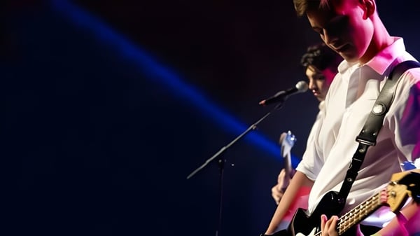 Una persona con camisa blanca y pantalones oscuros se presenta en el escenario del campus de la Mount Albert Grammar.