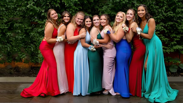 Un grupo de jóvenes estudiantes está frente a un fondo de hojas verdes en el campus de la Mount Anville Secondary School.
