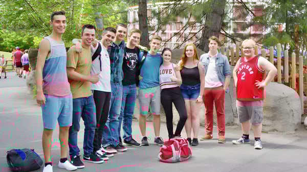 Un grupo de estudiantes está en la calle frente a edificios y árboles en el campus de la Mount Baker Secondary School.