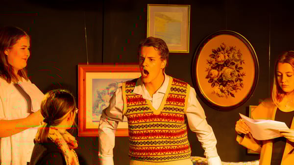 Un grupo de estudiantes está en el aula de arte de la Mount Barker High School frente a obras de arte enmarcadas en las paredes.