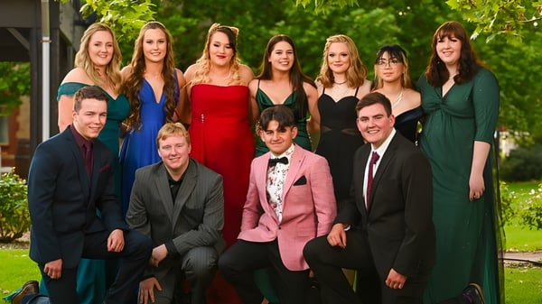 Un grupo de estudiantes de la Mount Compass Area School posan al aire libre frente a vegetación verde.