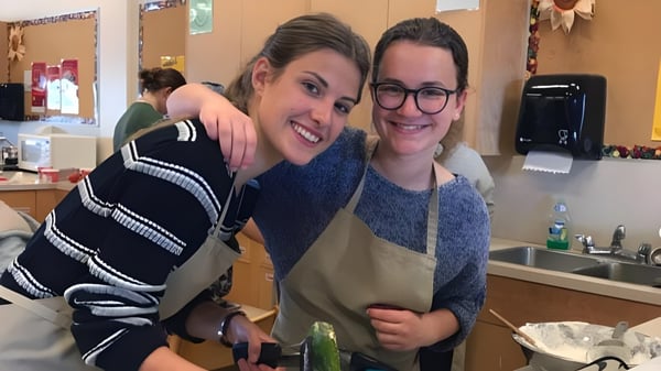 Dos personas se abrazan en un área de cocina en el campus de la Mount Douglas Secondary School.