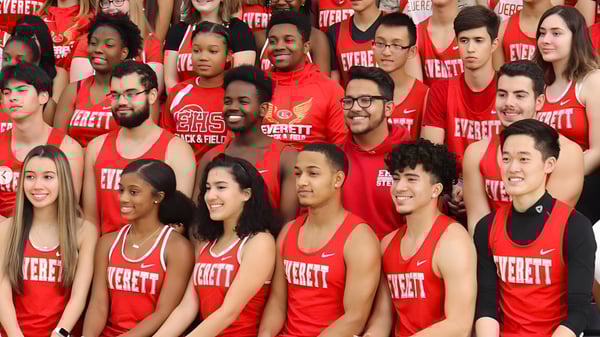 Un grupo de estudiantes en uniformes rojos de la Mount Everett Regional High School está junto en una multitud.
