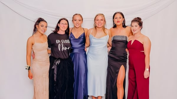 Un grupo de seis estudiantes del Mount Hutt College posan en vestidos de gala frente a un fondo blanco.