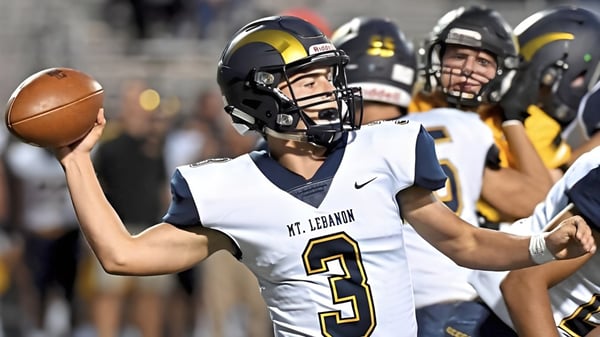Un futbolista con camiseta blanca con el número 3 sostiene el balón durante el partido nocturno de la Mount Lebanon High School.