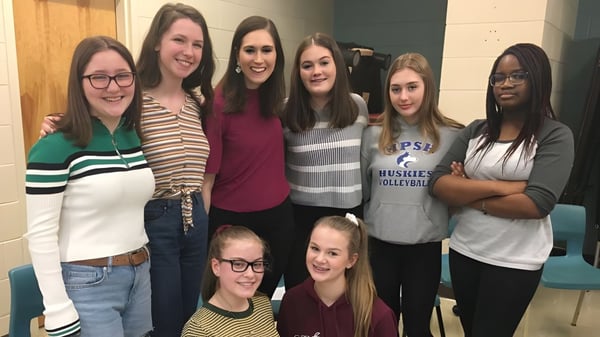 Un grupo de estudiantes se encuentra y sonríe juntos en el terreno de la Mount Pearl Senior High School.