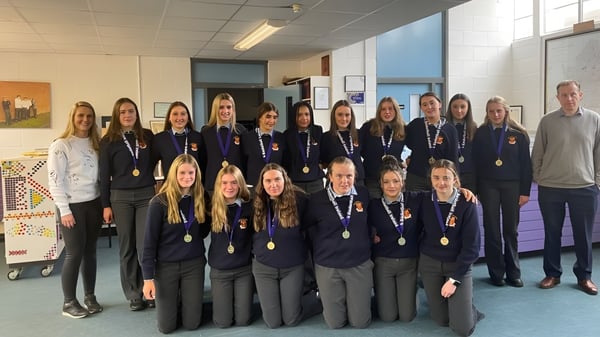 Un grupo de estudiantes de la Moyne Community School posa juntas en el aula.