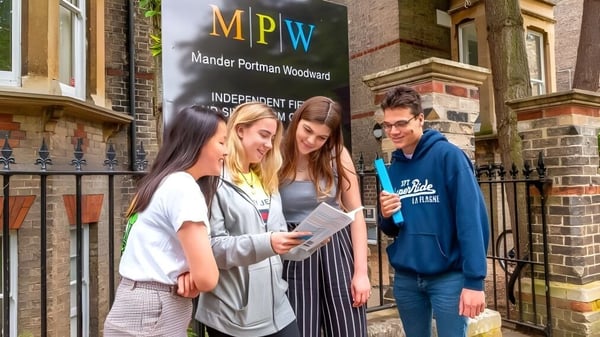 Un grupo de estudiantes está frente al edificio de MPW Birmingham y está conversando.