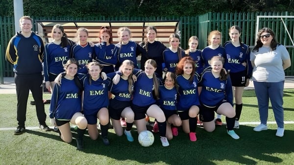 Un grupo de jugadoras de fútbol posan en el campo deportivo del Nagle Community College.