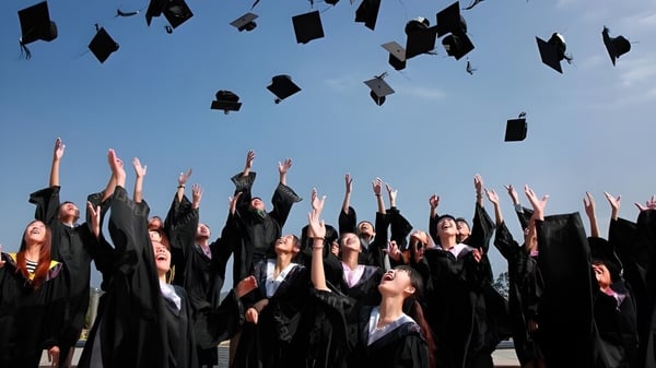 Los graduados de la Nakusp Secondary School lanzan sus birretes al cielo despejado.